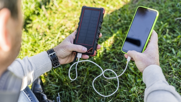 man charging his smartphone with a solar power bank