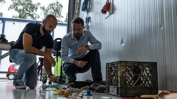 a couple of men looking at plastic waste