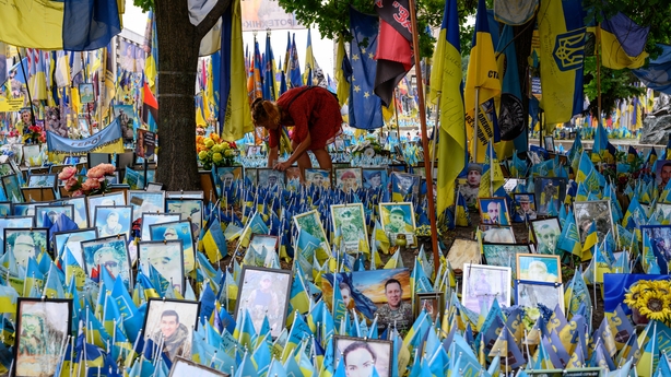 a person kneeling in front of flags