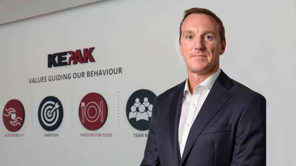 The Kepak CEO standing in front of a wall with the company's logo