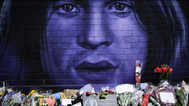 A photograph taken on July 23, 2025 shows flowers, candles and drawings left at a makeshift memorial by a mural depicting late British singer-songwriter Ozzy Osbourne, in Birmingham