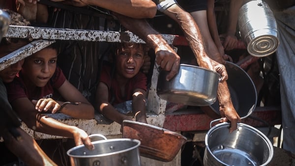Palestinians wait for food to be distributed by a charity organisation (Photo by Ali Jadallah/Anadolu via Getty Images)
