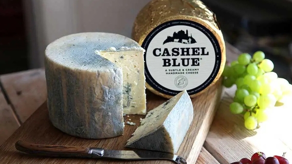 a Cashel Blue Cheese board with a knife and grapes