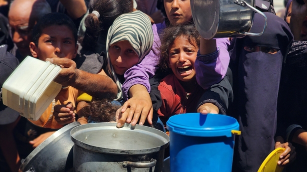KHAN YUNIS, GAZA - JULY 24: Palestinians struggling with hunger crowd around as a charity distributes food in the Al-Mawasi area of Khan Yunis, Gaza amid ongoing Israeli restrictions blocking humanitarian aid from reaching Gaza, on July 24, 2025. (Photo by Hani Alshaer/Anadolu via Getty Images)