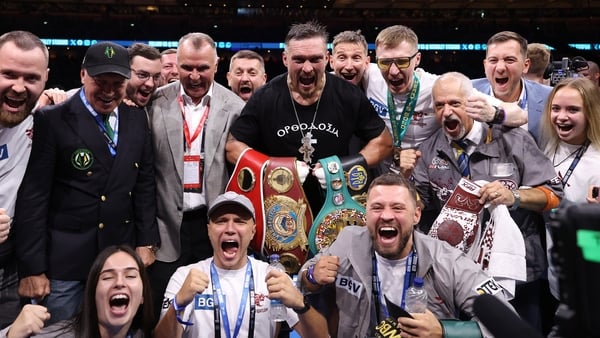 LONDON, ENGLAND - JULY 19: Oleksandr Usyk poses for a photo with the title belts and members of his team after victory over Daniel Dubois (not pictured) following their IBF, IBO, WBC and WBO World Heavyweight titles' fight on the 'Undisputed' fight night