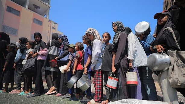 Young girls line up while waiting for food at an aid station in Gaza