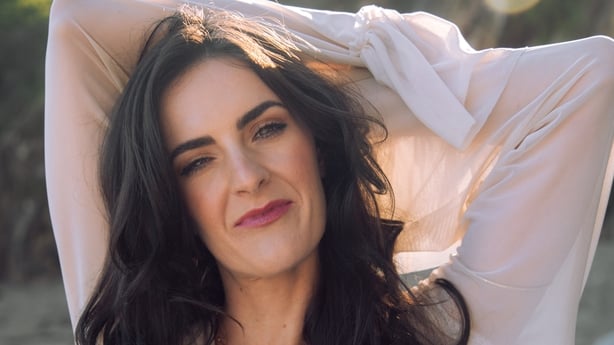 Ciara Ní É with her hands behind her head