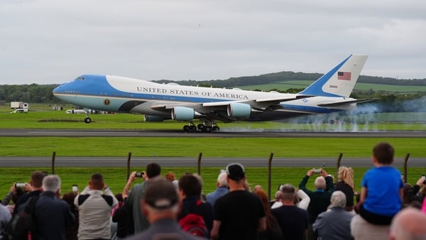 Trump supporters watch on as a plane carrying US President Donald Trump arrives at Prestwick Airport, before he heads over to his Turnberry golf course in South Ayrshire, as he begins his five-day private trip to the country. Picture date: Friday July 25,