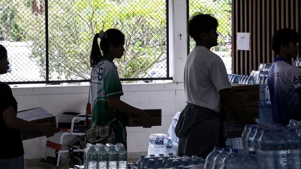 A group of people carry bottles of water