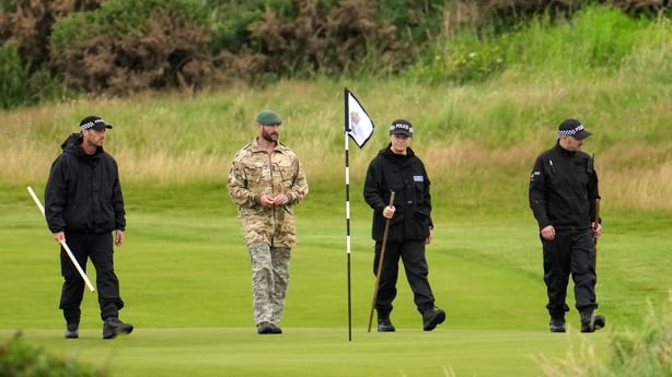 Police officers and soldiers search the first green at the Trump Turnberry course ahead of US President Donald Trump's visit