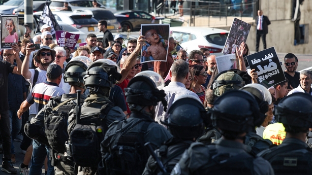 a group of people in riot gear holding signs