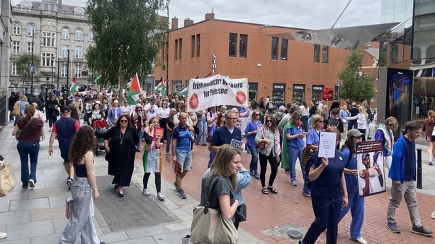 Healthcare workers march through the street