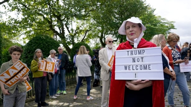 people stand around with signs during a protest