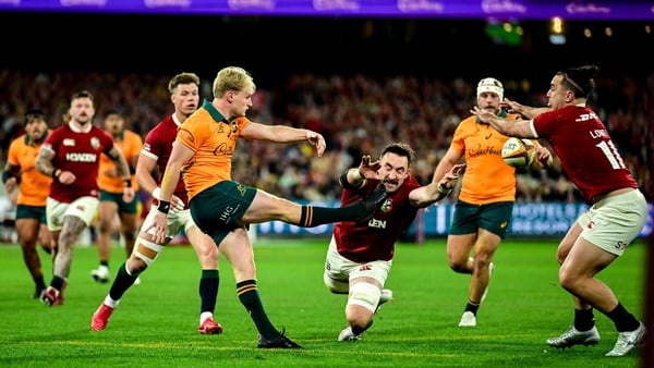 26 July 2025; Tom Lynagh of Australia clears uner pressure from British & Irish Lions players Jack Conan, centre, and James Lowe during the second test match between Australia and the British & Irish Lions at the Melbourne Cricket Ground in Melbourne, Aus
