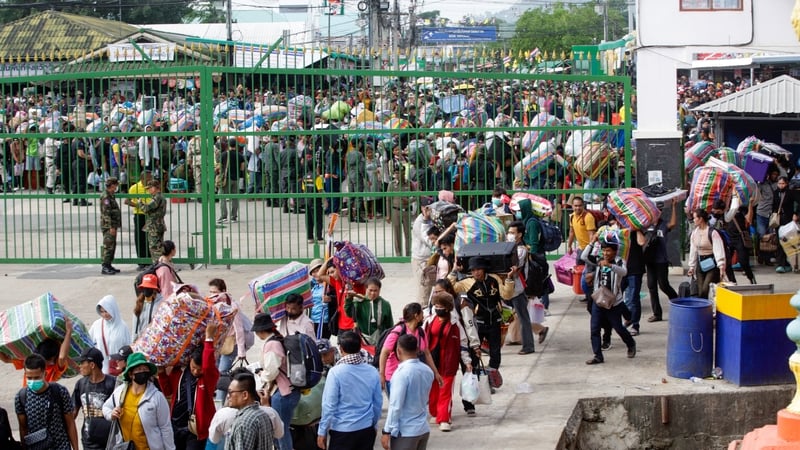 Cambodian migrant workers carry their belongings as they return from Thailand through the Doung International Gate in Battambang province