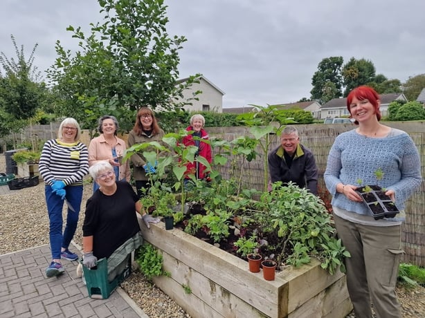 a group of people standing in a garden