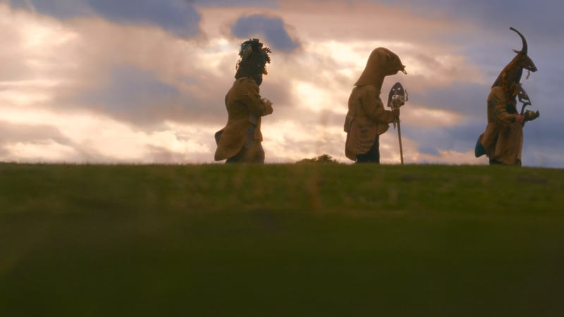 a group of people in clothing walking on a hill