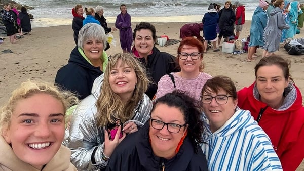 a group of people posing for a photo on a beach