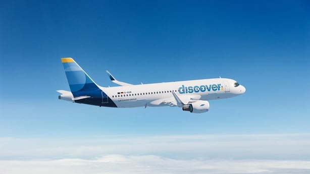 a plane flying in the sky with the Discover logo on it