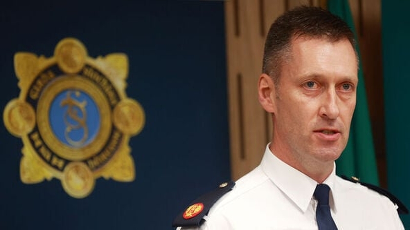 Justin Kelly in his garda uniform with the symbol of An Garda Síochána in the back