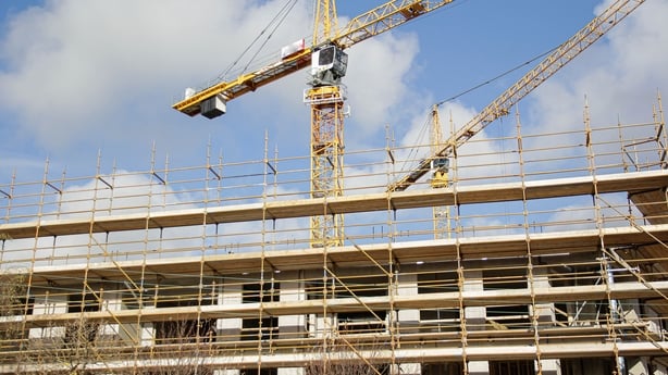 Construction site showing cranes and scaffolding