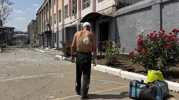 Injured man stands next to building in Zaporizhzhia