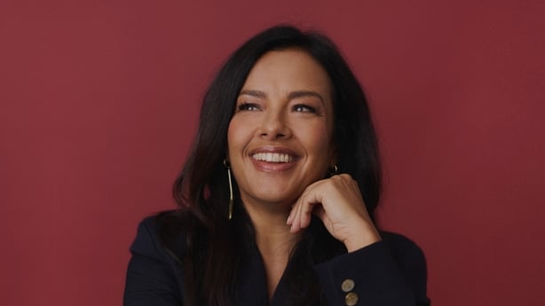 TV presenter Liz Bonnin smiling with her hand on her chin in a posed photo