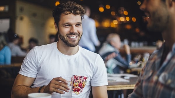 Two male friends talking in a cafe.