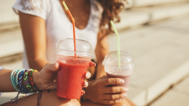 Two women sitting and drinking smoothies