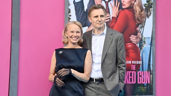 Pamela Anderson and Liam Neeson pose for a photo together on the red carpet at the Naked Gun premiere in New York.
