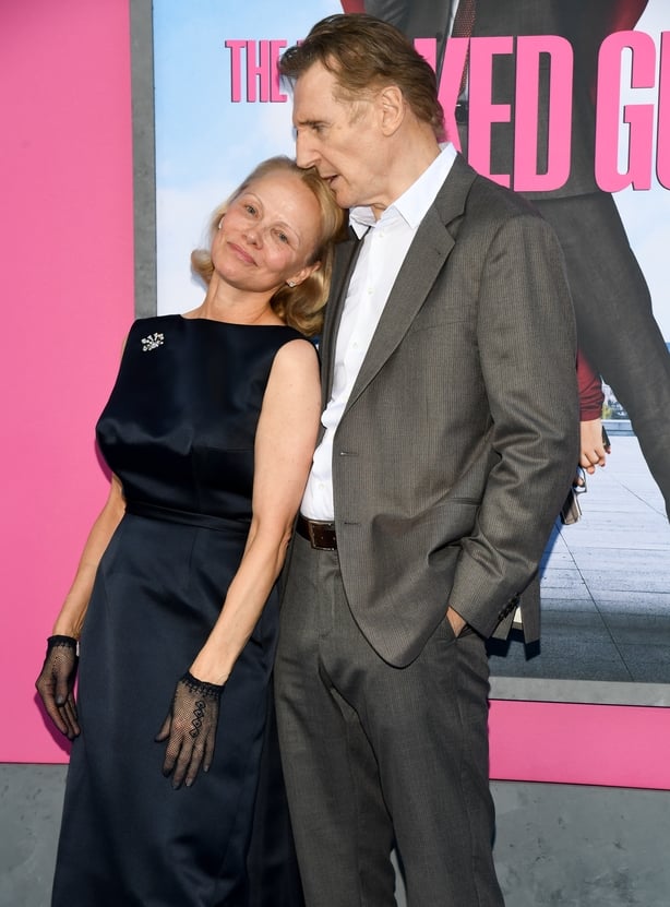 Pamela Anderson and Liam Neeson pose for a photo together on the red carpet at the Naked Gun premiere in New York.