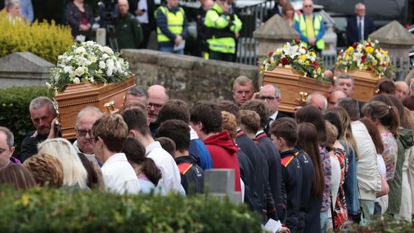 Three coffins carrying remains of Vanessa Whyte and her children are carried into St Mary's Church in Maguiresbridge as people watch on
