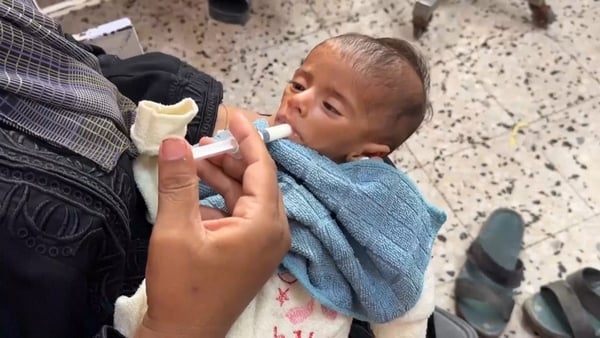 A malnourished baby wrapped in a blue blanket receives treatment at Nasser hospital in Gaza