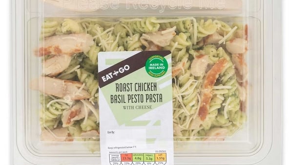 some yellow and green pasta is seen in a clear box with a label that reads roast chicken basil pesto pasta