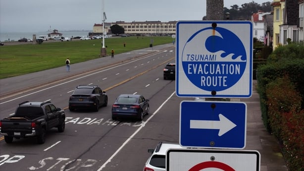 a road with a tsunami evacuation sign on it