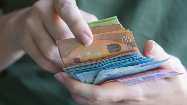 A close-up of hands holding a variety of colorful Euro banknotes, fanned out to display different denominations. The image highlights the vibrancy of the currency and suggests themes of finance, savings, wealth, and personal budgeting. Perfect for illustr