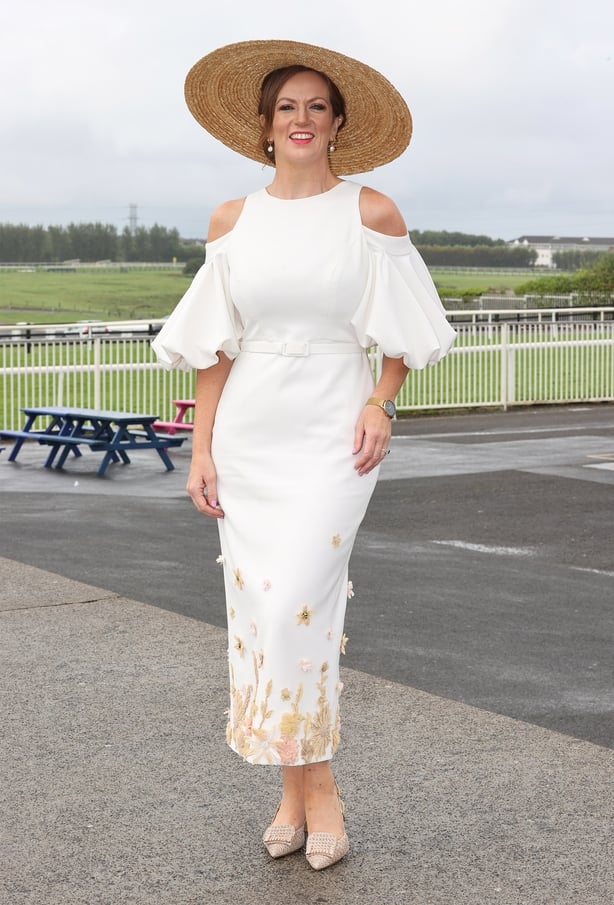 a woman in a white dress and straw hat