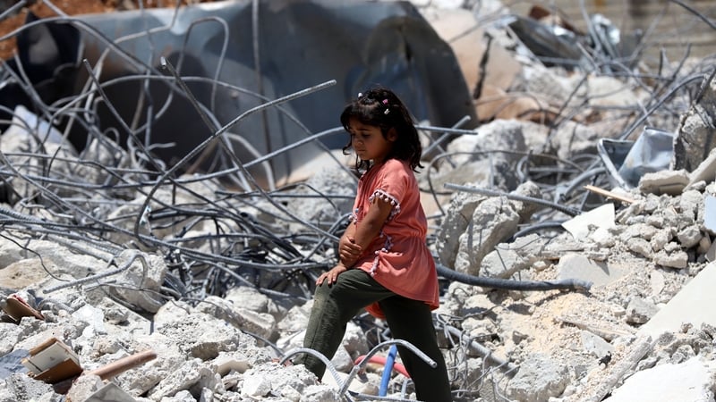A Palestinian girl stands on the rubble of her house that was demolished by Israeli forces in the occupied West Bank