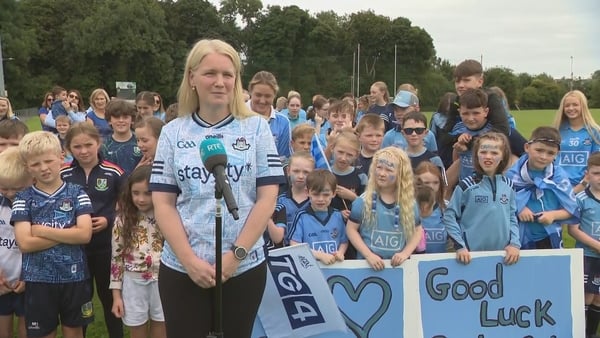 Noeleen Malone, chairperson of Clann Mhuire with crowds of young Dublin supporters behind her