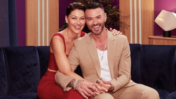 Love is Blind hosts Emma Willis and Matt Willis smile for the camera as they hold hands