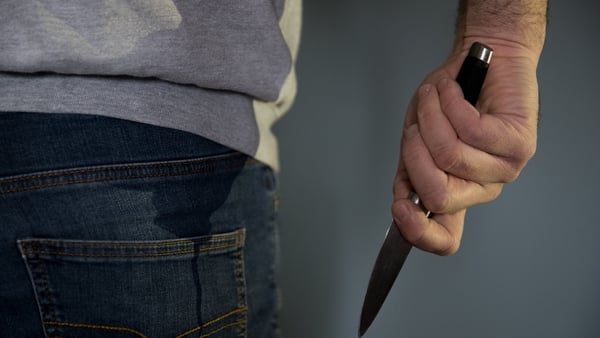A model posing while holding a knife