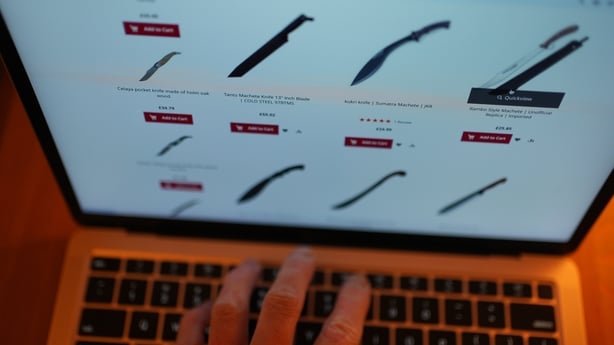 a person using a laptop to view knives available to purchase via an online website