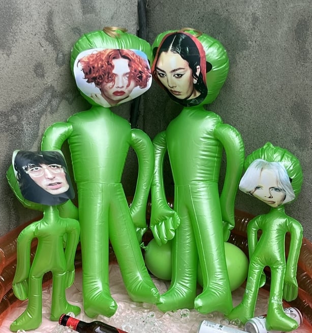 a group of green inflatable aliens