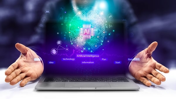 A man holding a laptop with a computer generated image of a brain and the AI symbol