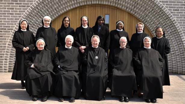 a group of people wearing black robes