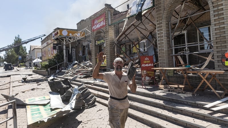 A man walks past damaged buildings after a Russian drone strike hit a market area in Druzhkivka, Ukraine