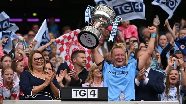 Dublin captain Carla Rowe lifts the Brendan Martin cup, alongside Uachtarán Cumann Peil Gael na mBan, Trina Murray, left, after the TG4 All-Ireland Ladies Football Senior Championship final match between Dublin and Meath at Croke Park in Dublin.
