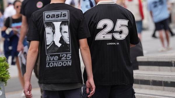 Fans wearing Oasis merchandise are seen outside the stadium ahead of the first night of the Oasis Live '25 tour opening at Wembley Stadium in London on 25 July, 2025