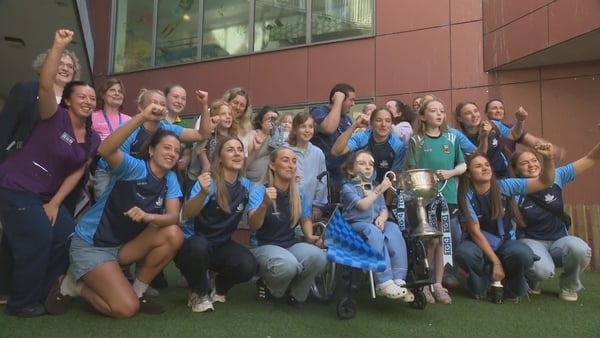 A group of women celebrate with the trophy