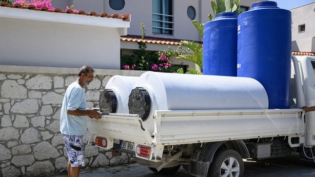 Water tanks are loaded onto a truck to deliver them to hotels in Izmir, west Turkey
